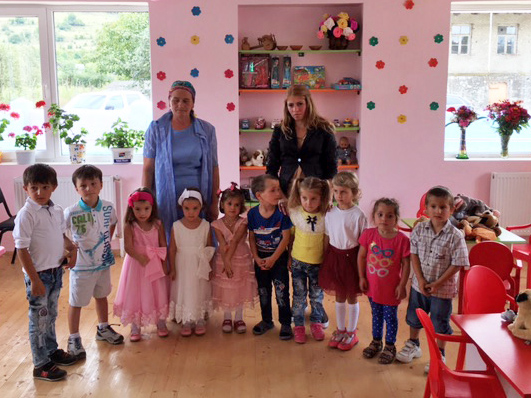 Kinder mit ihren Betreuerinnen im neuen, rosa gestrichenen Spielzimmer in Koreti.